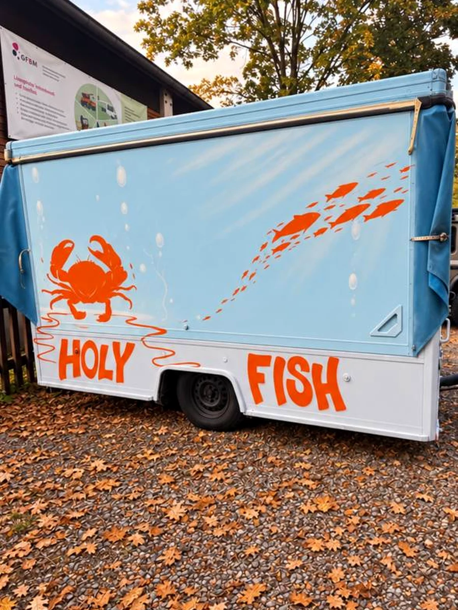 Hellblauer Holy Fish Verkaufswagen mit orangefarbenem Krabben- und Fischmotiv