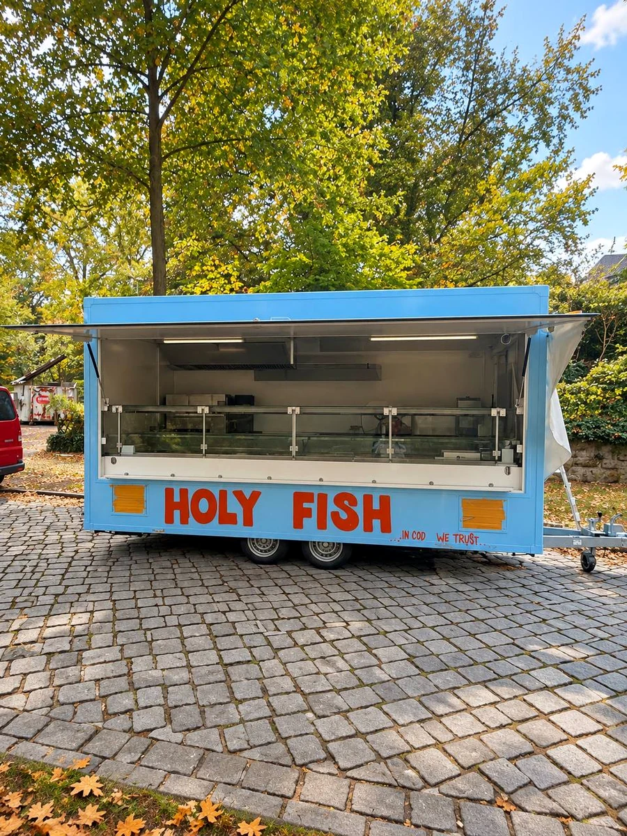 Geöffneter hellblauer Holy Fish Verkaufswagen mit großer Verkaufstheke