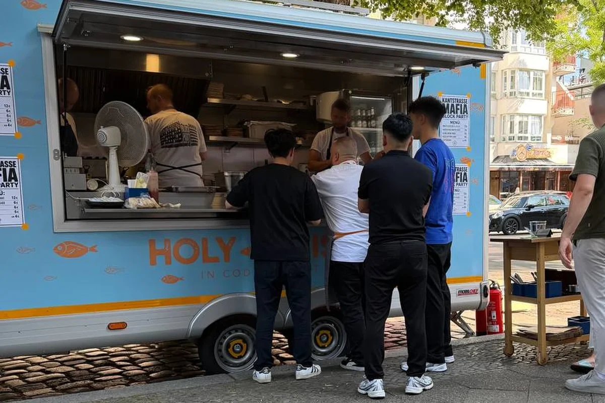Holy Fish Trailer im Einsatz; sichtbare Gesichter am Ausgabefenster sind aus Datenschutzgründen weichgezeichnet